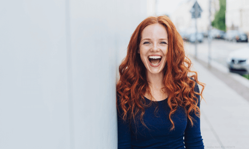 gynefix anwenderin mit roten haaren grinst gluecklich aufgrund der hohen vertraeglichkeit der verhuetung ohne hormone